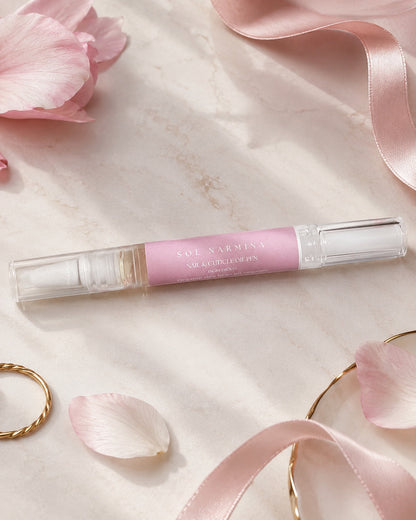 Sol Narmina Nail & Cuticle Oil Pen flat lay with pink ribbon and petals